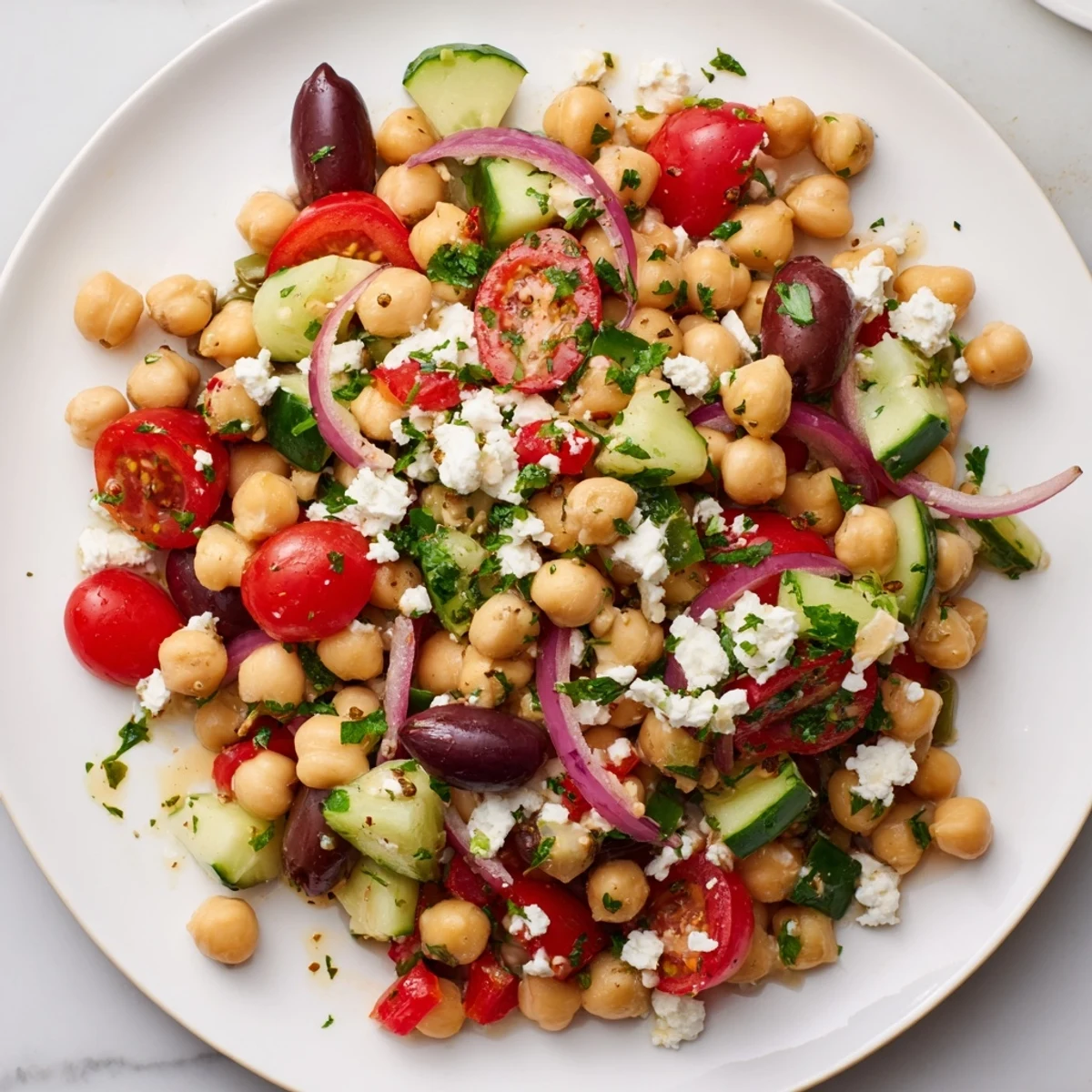 A colorful Mediterranean Chickpea Salad with feta, olives, and fresh herbs, ready to serve.
