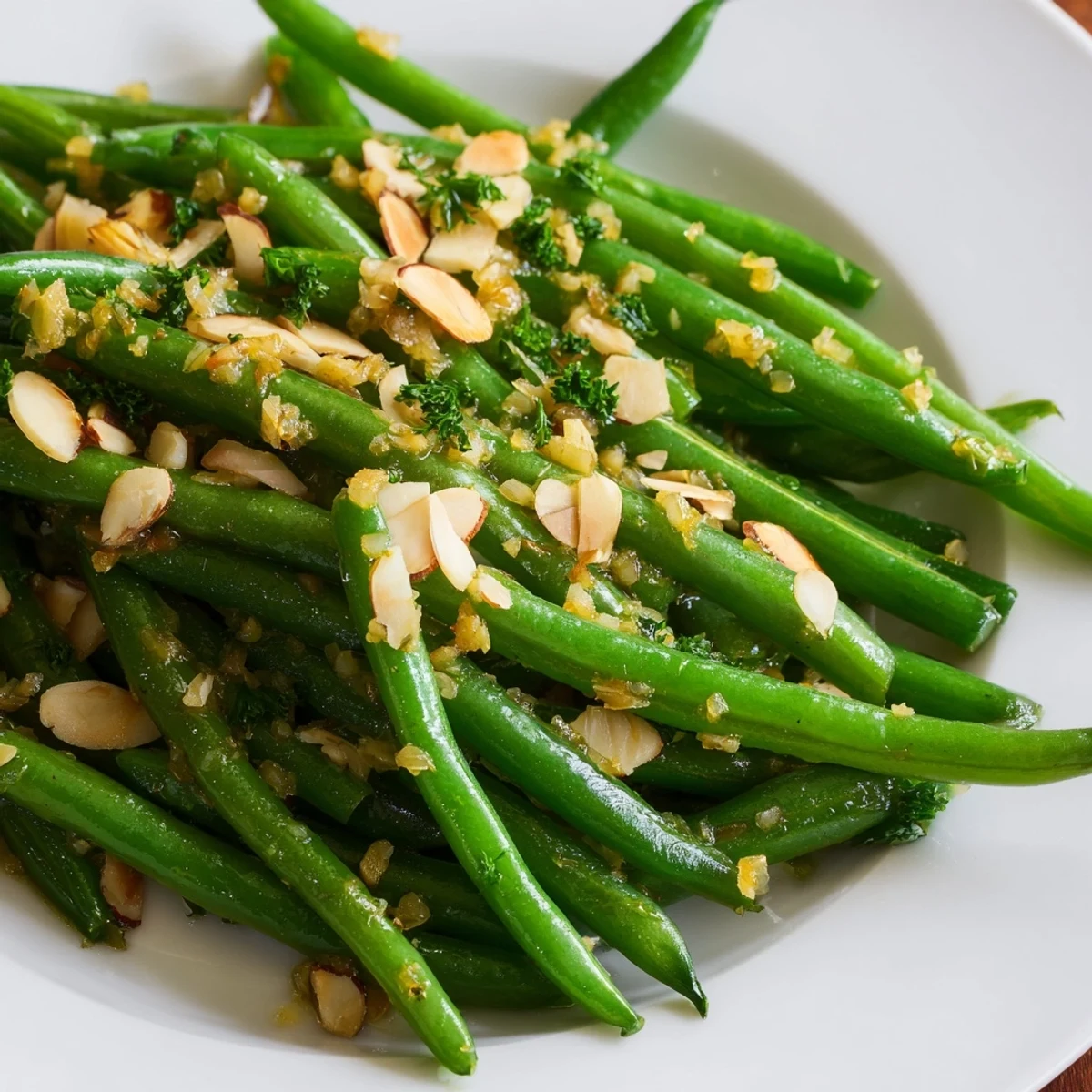 Freshly cooked green beans in a bright lemon dressing, topped with toasted almonds and parsley, served as a zesty side dish.