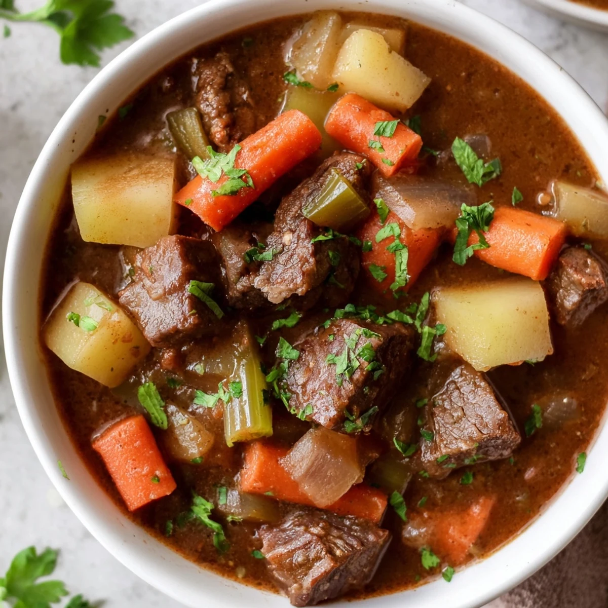 Slow Cooker Beef and Vegetable Stew cooks on high heat, with bubbling gravy and soft potatoes inside a large ceramic crock.