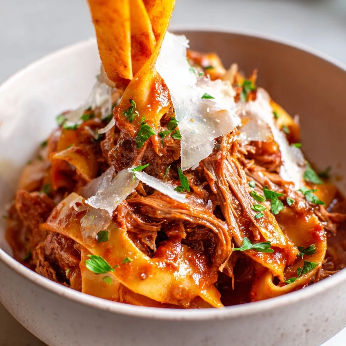 Steaming bowl of Slow Cooker Beef Ragu with fresh parsley and grated Parmesan, ready to serve.