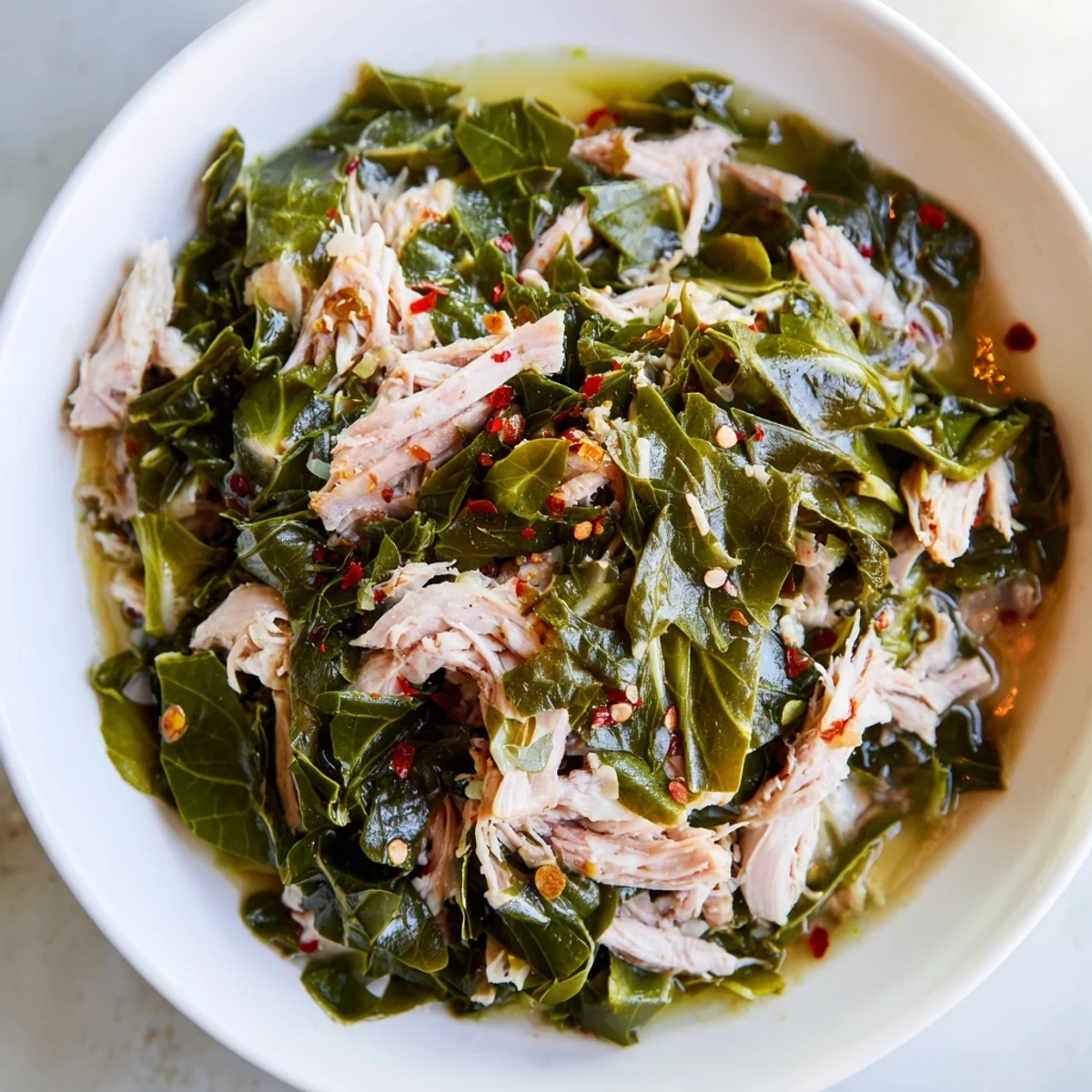 Tender Southern Collard Greens with Smoked Turkey served in a bowl, savory aroma with onions and garlic.  
