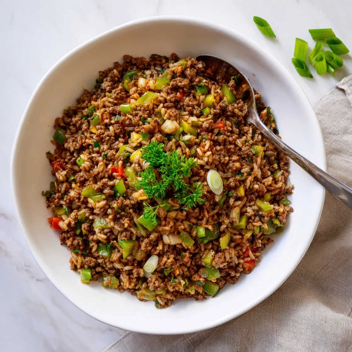 Mardi Gras Dirty Rice is served in a skillet, topped with green onions and ready to enjoy.