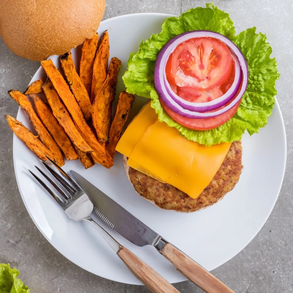 Savor a colorful plate of a turkey burger with sweet potato fries, ready for a casual family meal.
