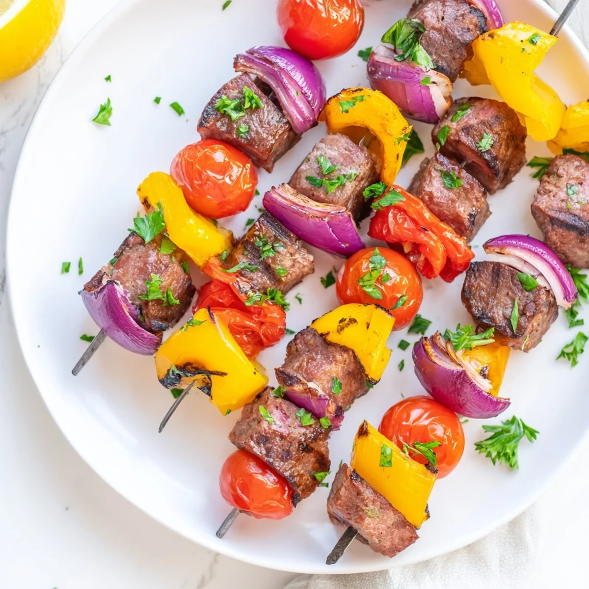 Juicy Beef Sausage Skewers with Peppers sizzling on the grill, showing charred red and yellow peppers alongside tender, browned sausage pieces.