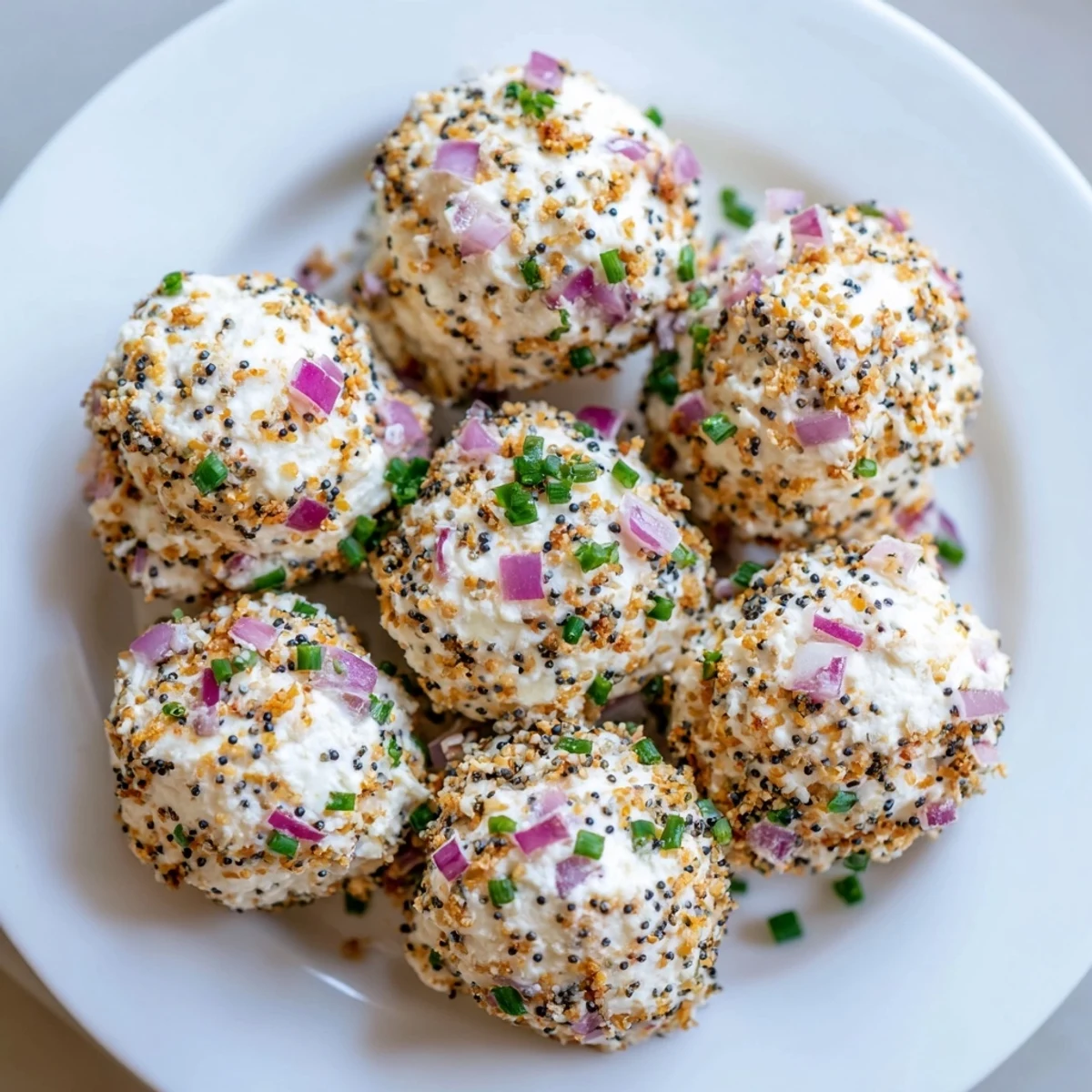 Golden-brown everything bagel bites on a white platter, Everything Bagel Cottage Cheese Bites ready for snacking.