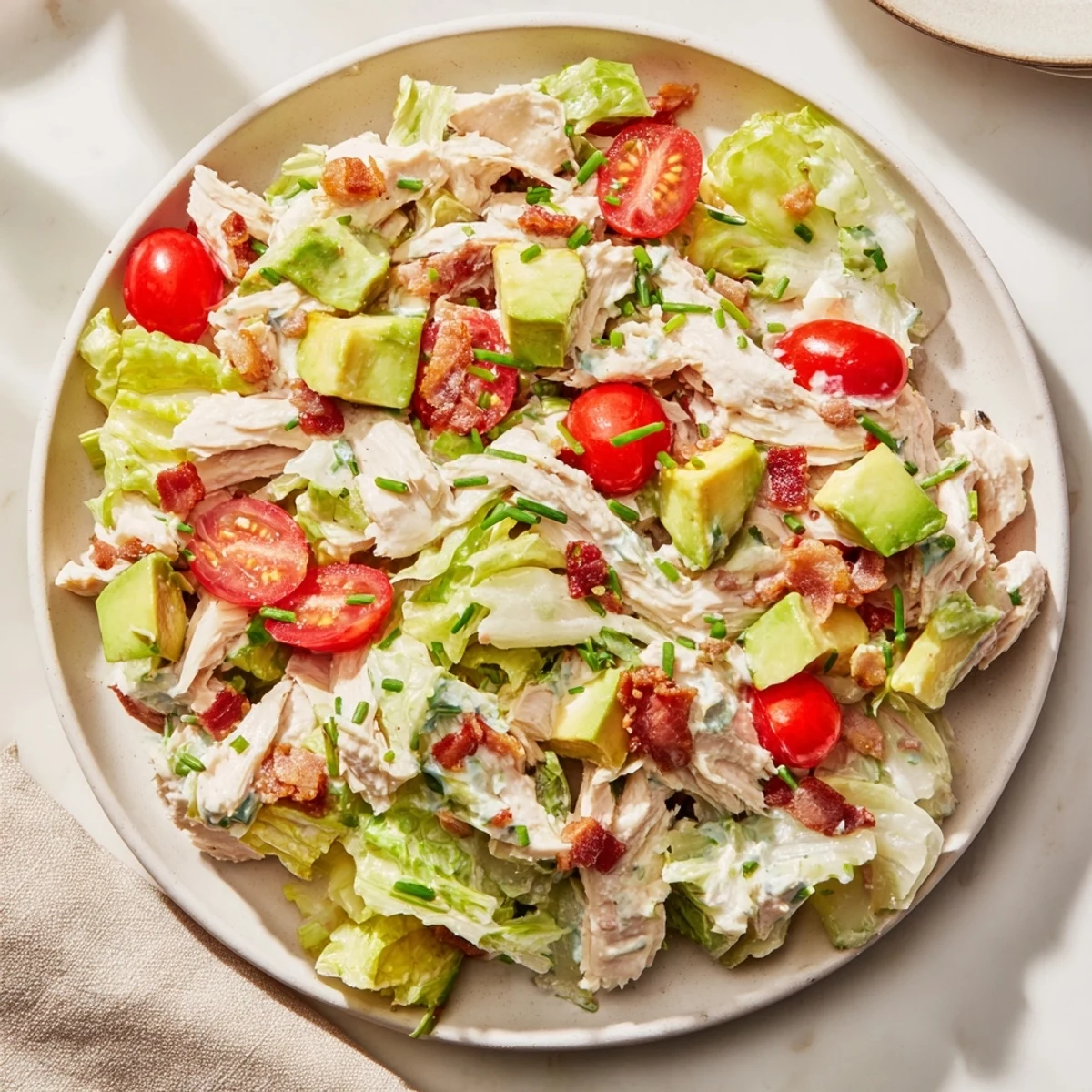 A close-up shows tender chicken, fresh lettuce, and creamy dressing tossed together for a satisfying BLT Chicken Salad lunch.