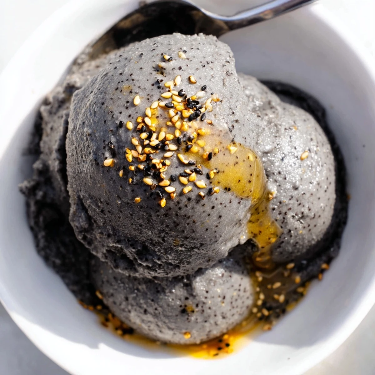 A close-up view of luscious toasted black sesame ice cream reveals its smooth texture and speckled seeds, perfect for inspiring U.S. dessert enthusiasts.