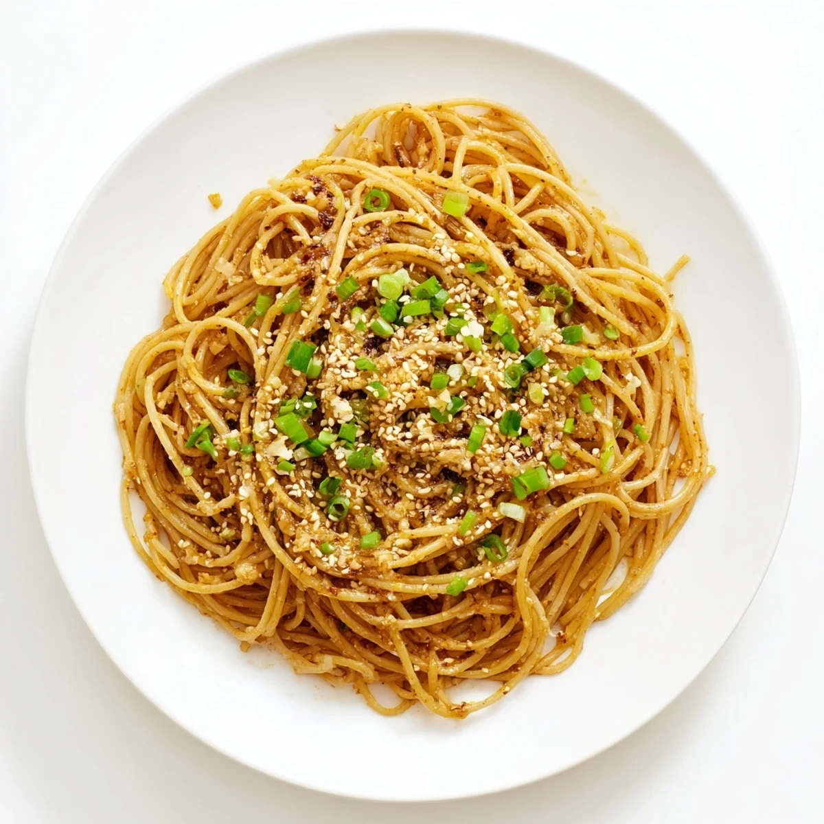 Garlic Noodles glisten in a skillet with melted butter, minced garlic, and soy sauce, topped with scallions and sesame seeds for a quick vegetarian dinner.