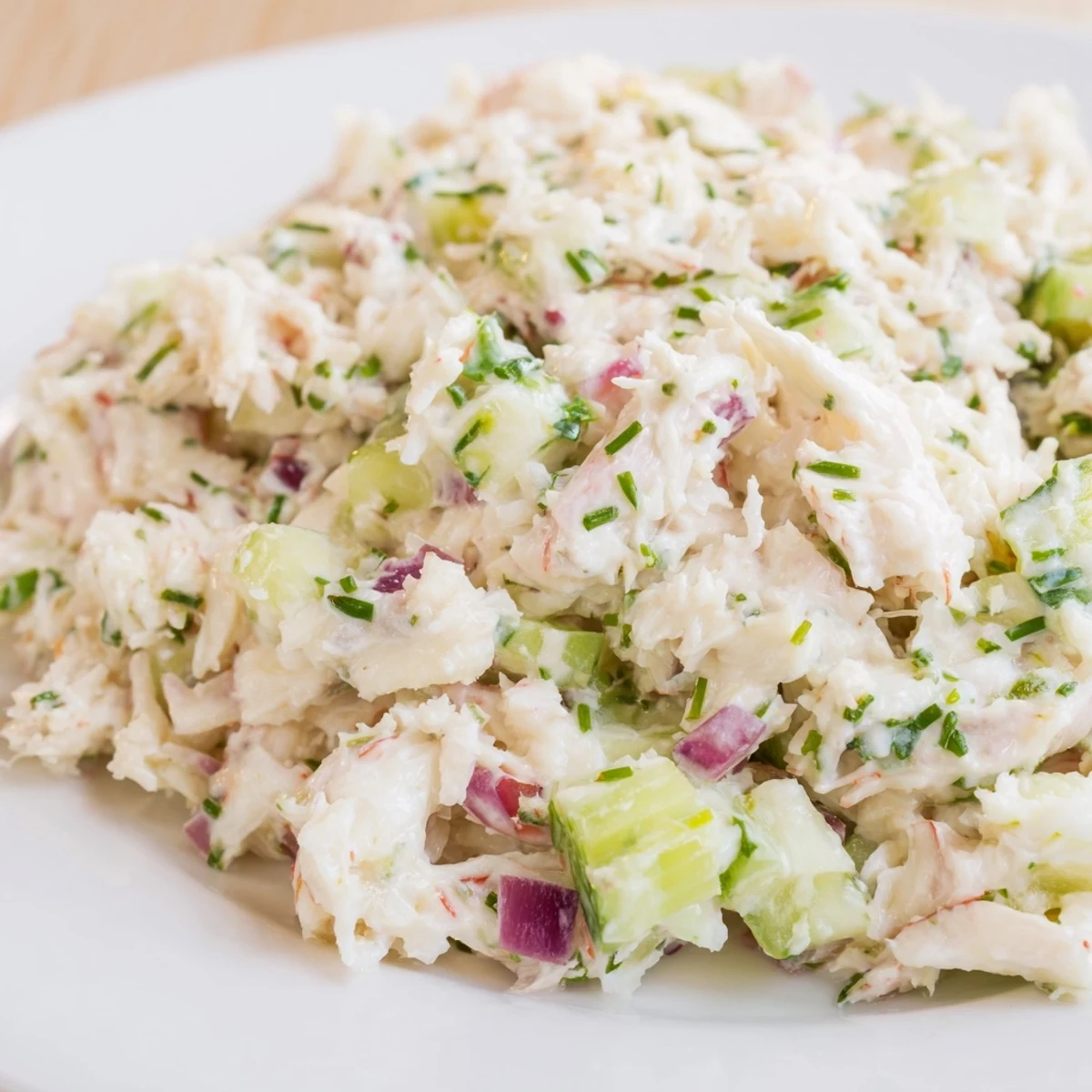 Chilled Crab Salad with lemon wedges and fresh herbs on a plate.