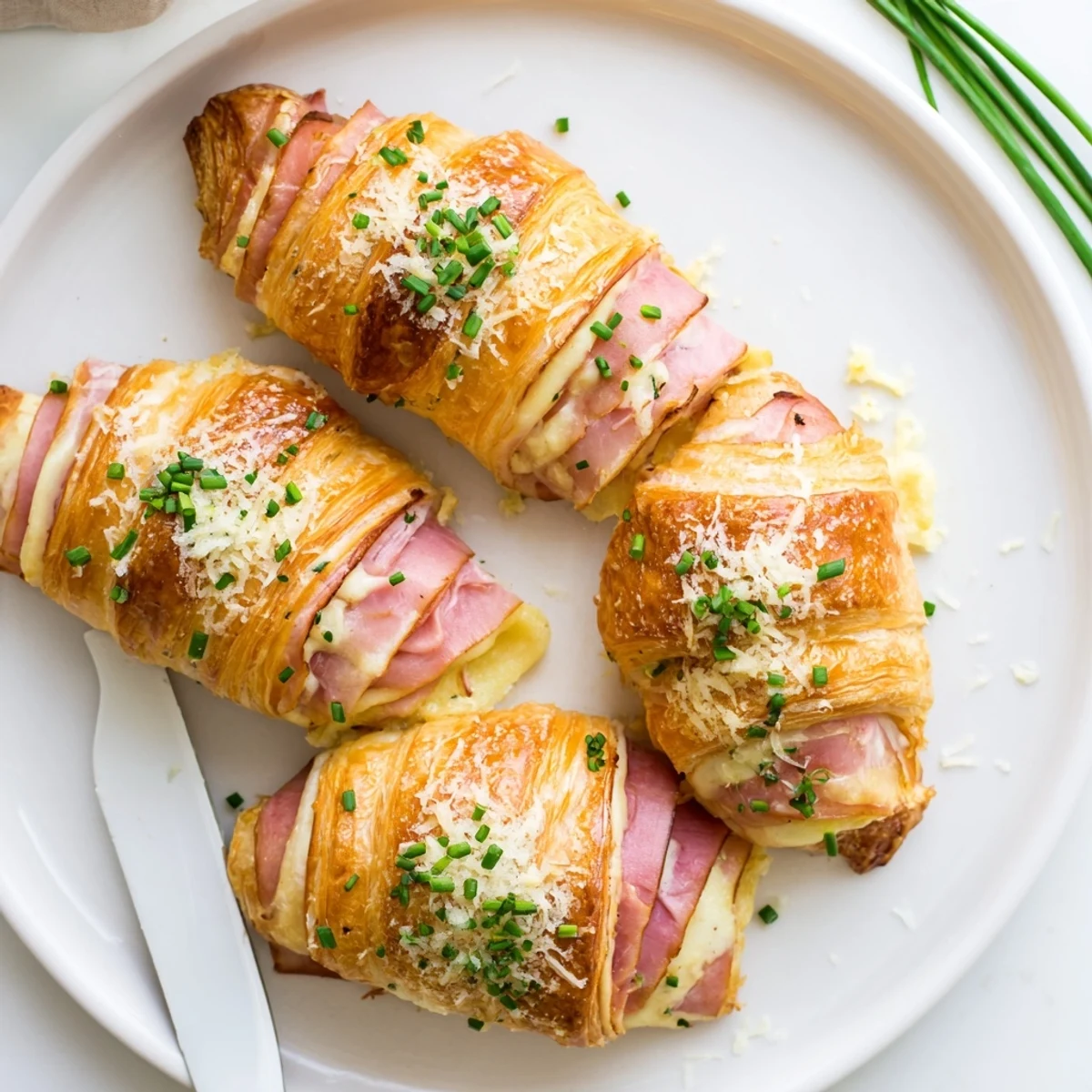 Warm Stuffed Croissants reveal flaky layers, savory ham, and creamy Dijon sauce beside a fresh green salad.  