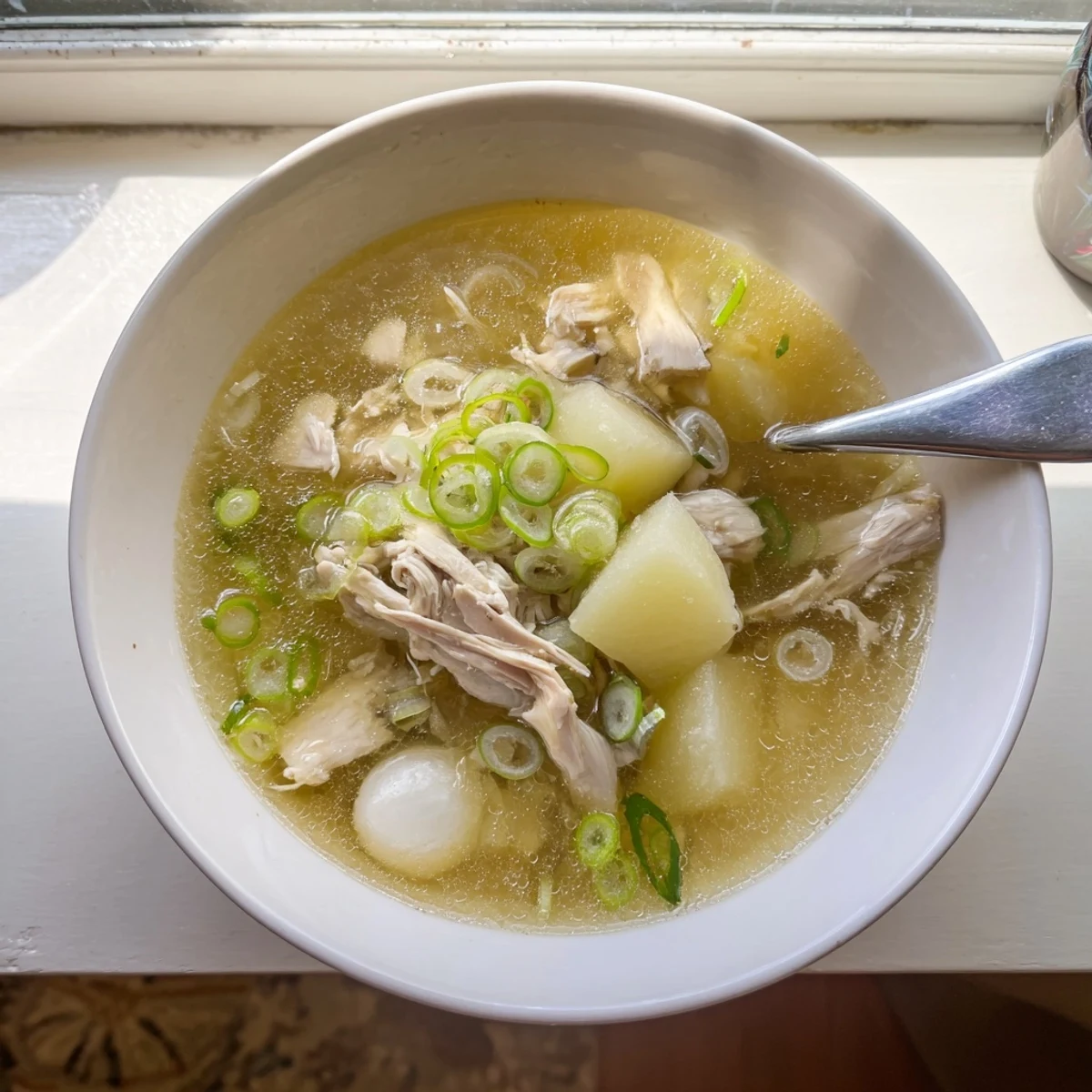 Steaming bowl of Dakgomtang Korean chicken soup topped with fresh green onions