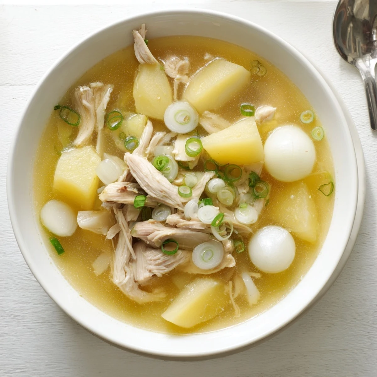 Comforting Dakgomtang soup featuring tender shredded chicken in clear aromatic broth