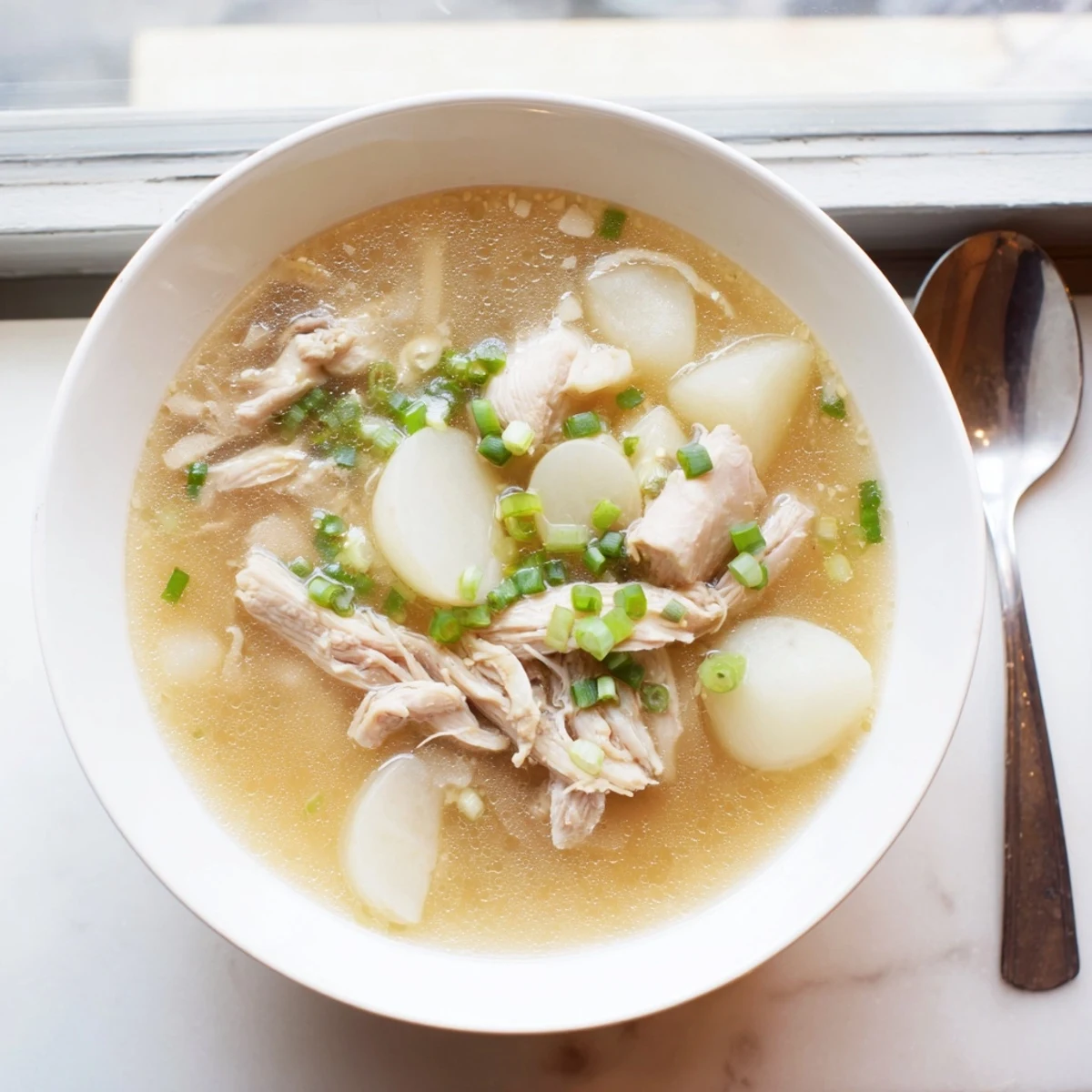 Dakgomtang Korean chicken soup garnished with sliced scallions and served piping hot