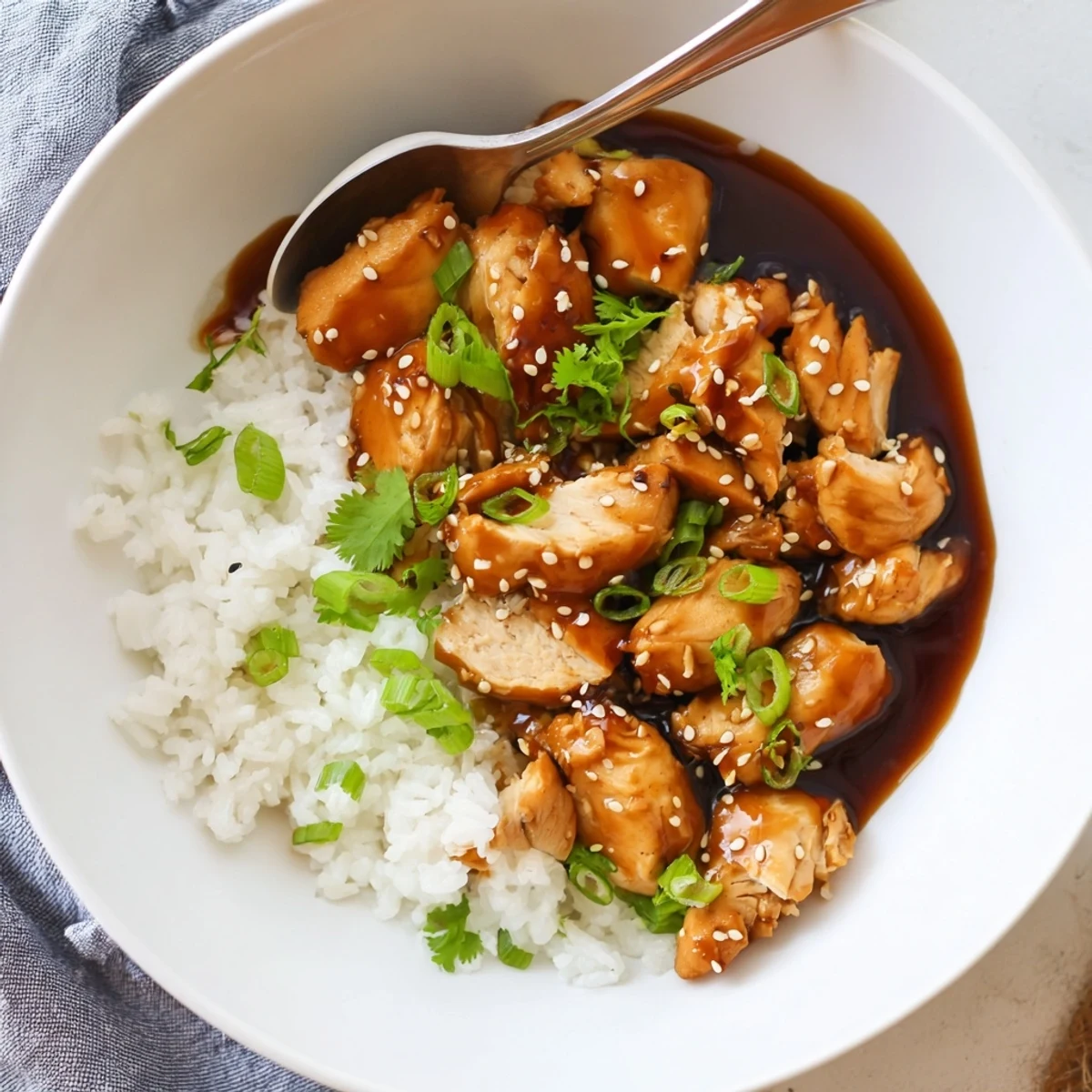 Golden caramelized soy chicken thighs swimming in aromatic garlic ginger broth over fluffy white rice