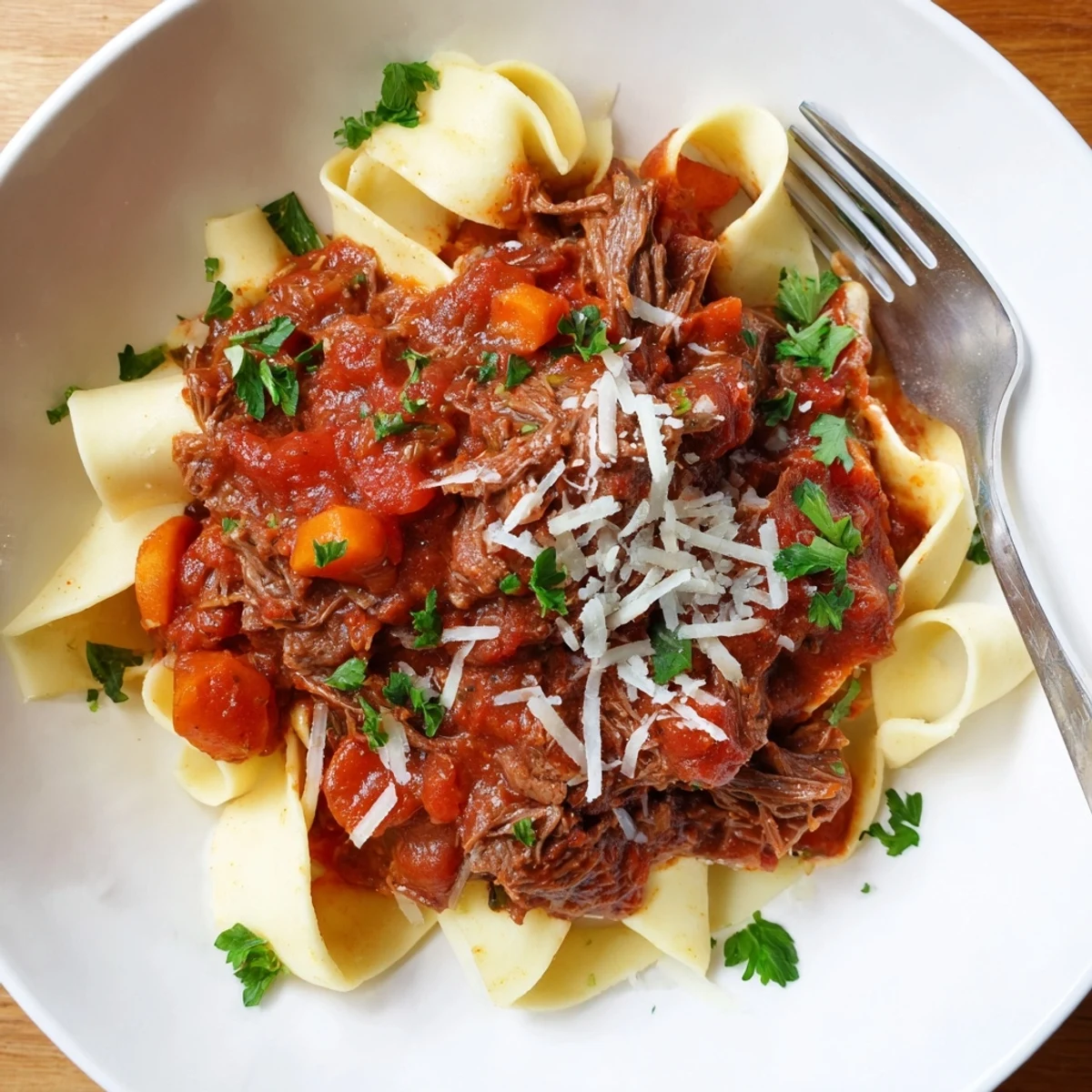 Hearty slow cooker beef ragu featuring fork-tender beef chunks braised in red wine and herbs