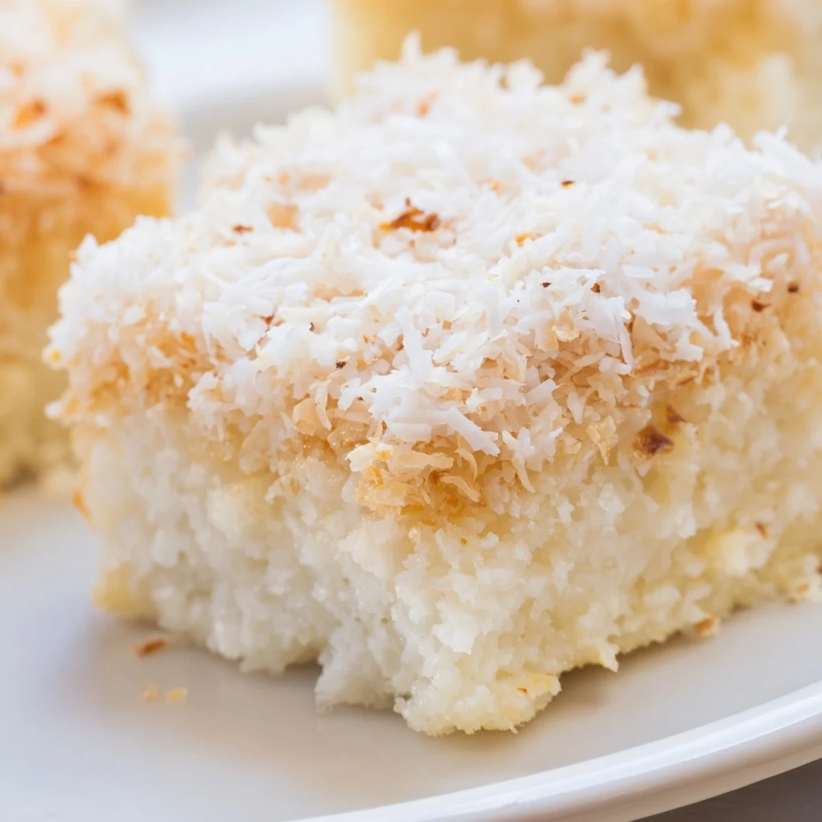Chewy gluten-free coconut mochi cake with golden edges and generous coconut topping, ready to serve