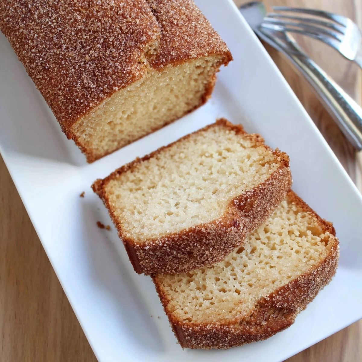 Golden cinnamon sugar donut bread loaf with sweet crunchy coating on a white plate