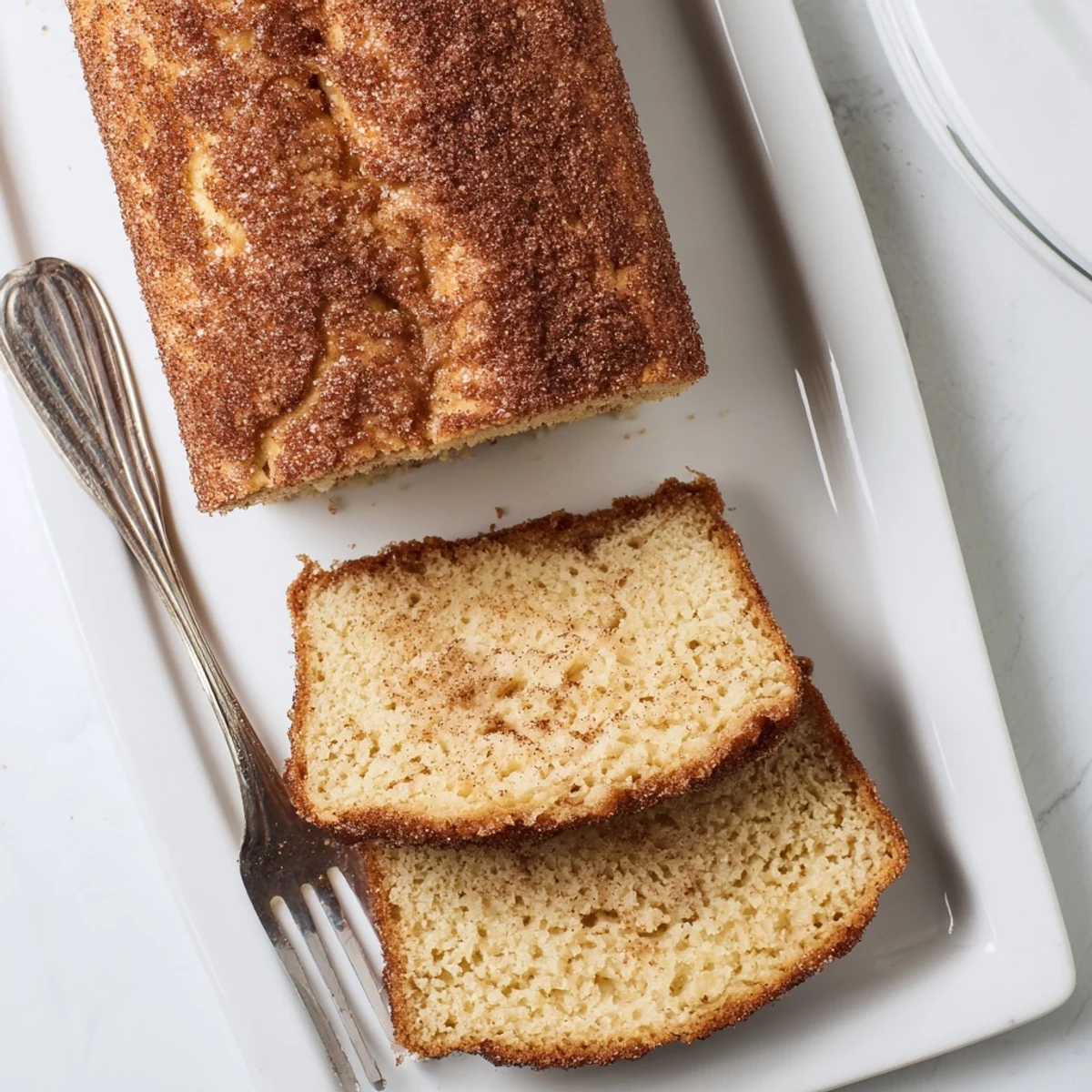 Moist cinnamon sugar donut bread slice revealing tender crumb with speckled spice throughout