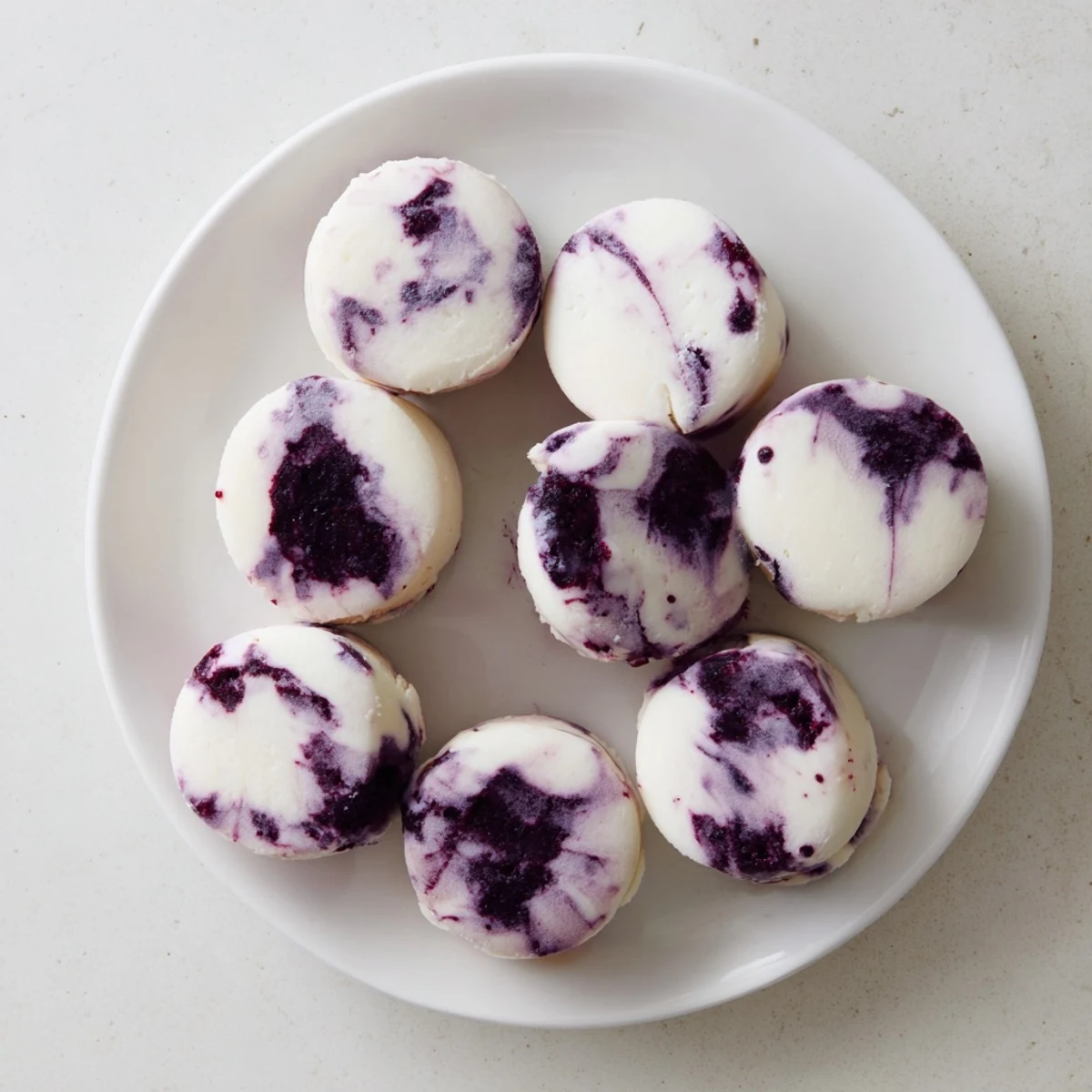Healthy blueberry swirl yogurt bites in a silicone muffin tray ready for freezing