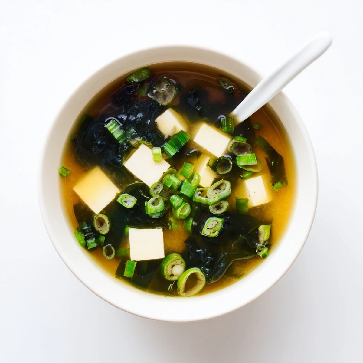 Comforting easy miso soup with fluffy tofu, dried wakame, and scallion slices floating in savory dashi broth