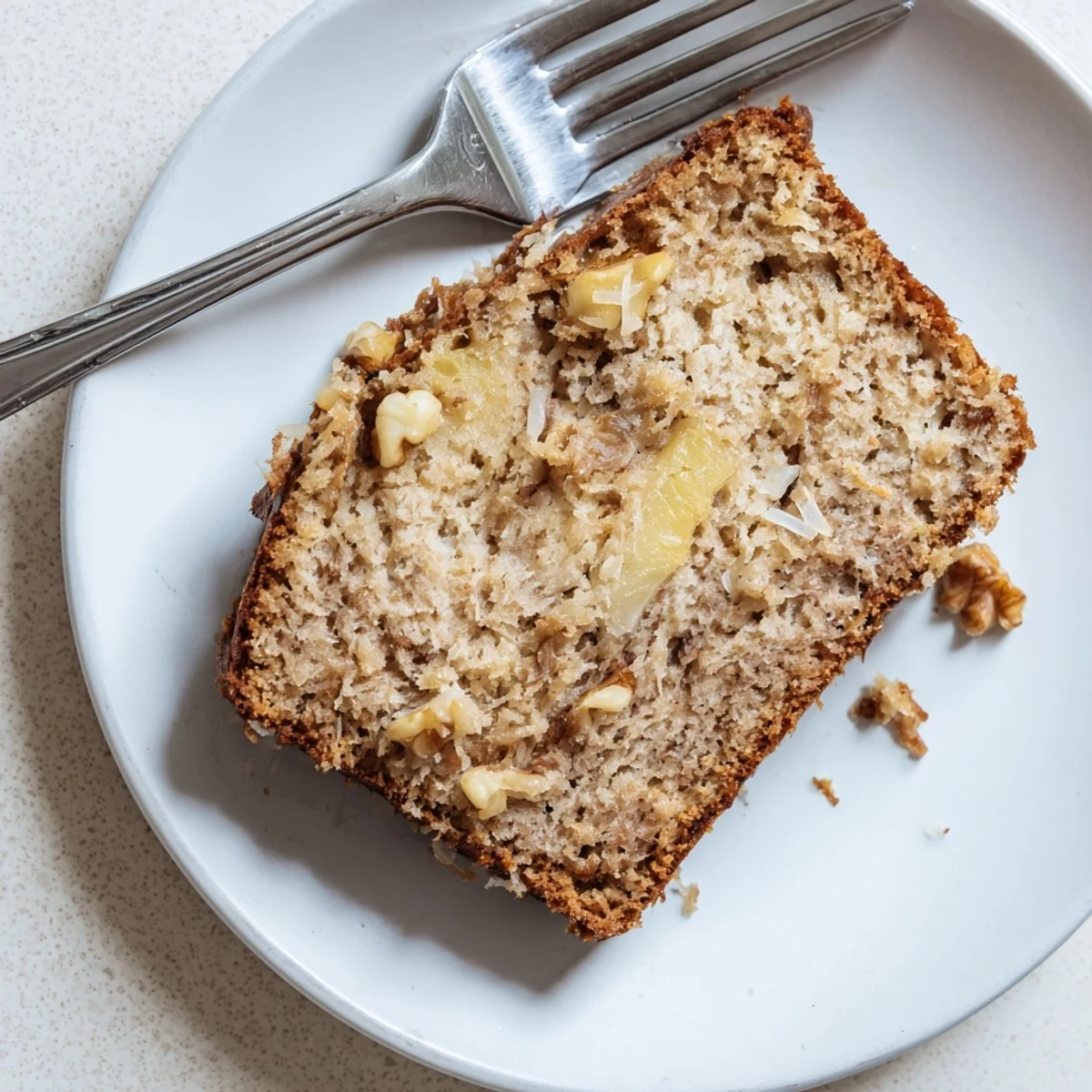 Freshly baked coconut pineapple banana bread cooling on wire rack with a golden brown crust