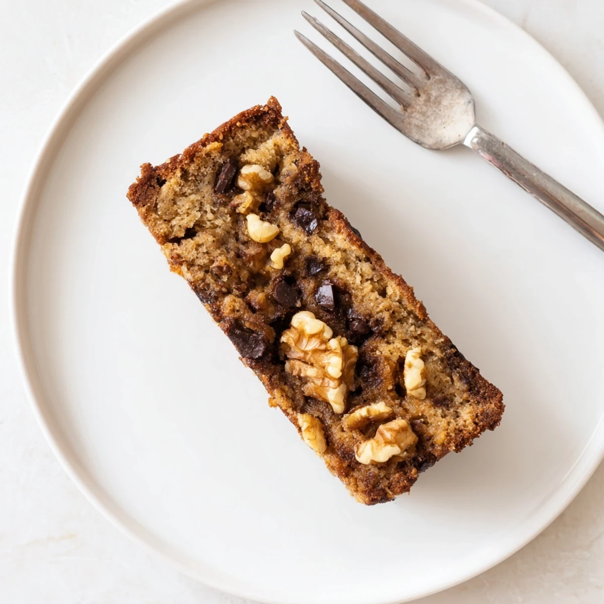 Moist low carb banana bread with a perfect crumb texture served on a white plate