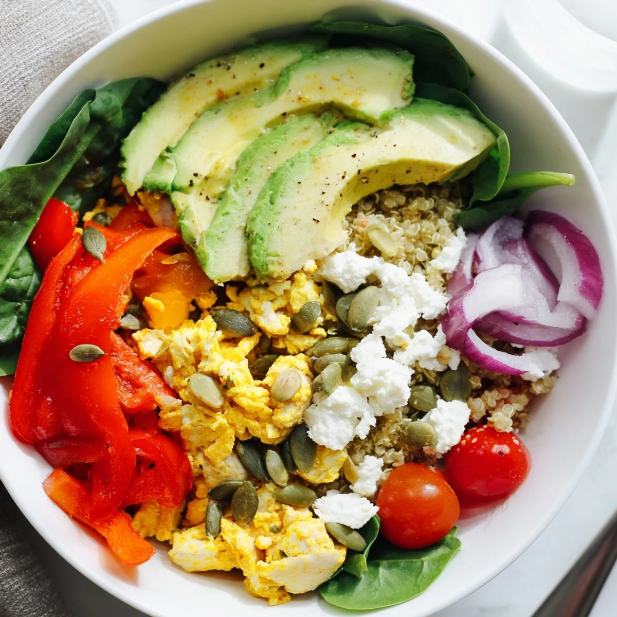 Customizable Easy High Protein Breakfast Bowl topped with crumbled feta, crisp bell peppers, and creamy avocado slices for a satisfying morning meal