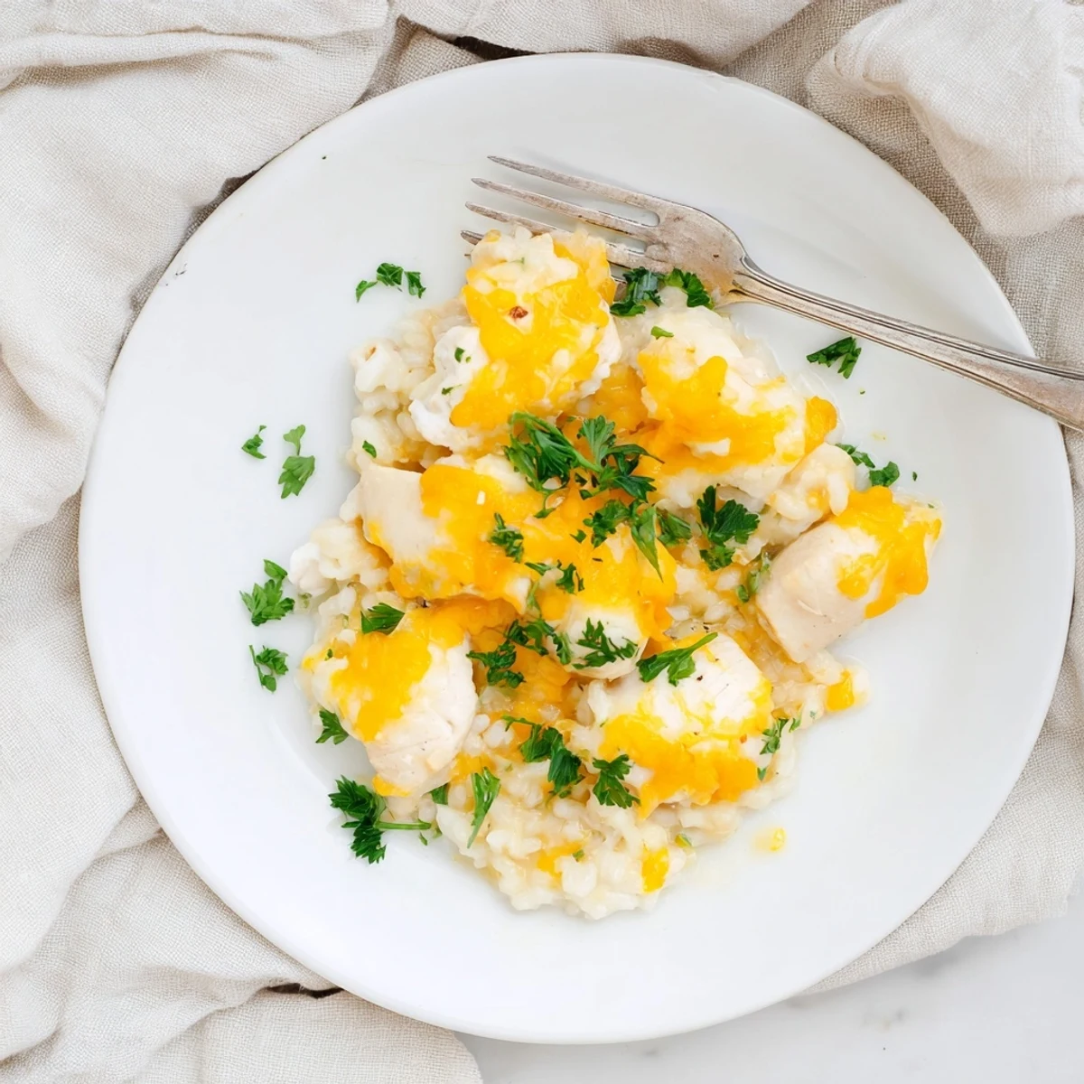One-pan smothered chicken and rice dish garnished with fresh chopped parsley