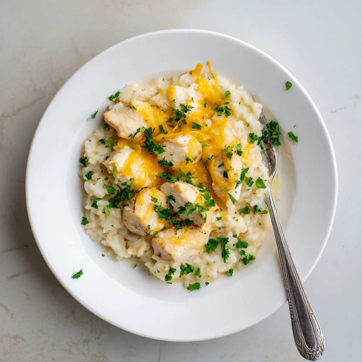 Golden brown chicken breasts nestled in creamy rice with melted cheddar cheese topping