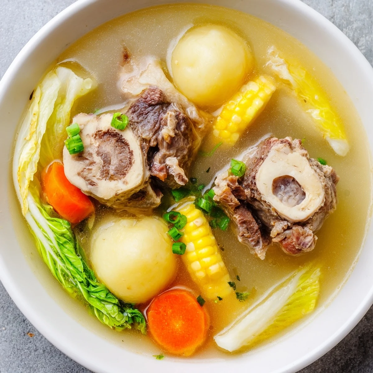 Filipino Bulalo beef shank soup featuring corn, cabbage, and rich bone marrow