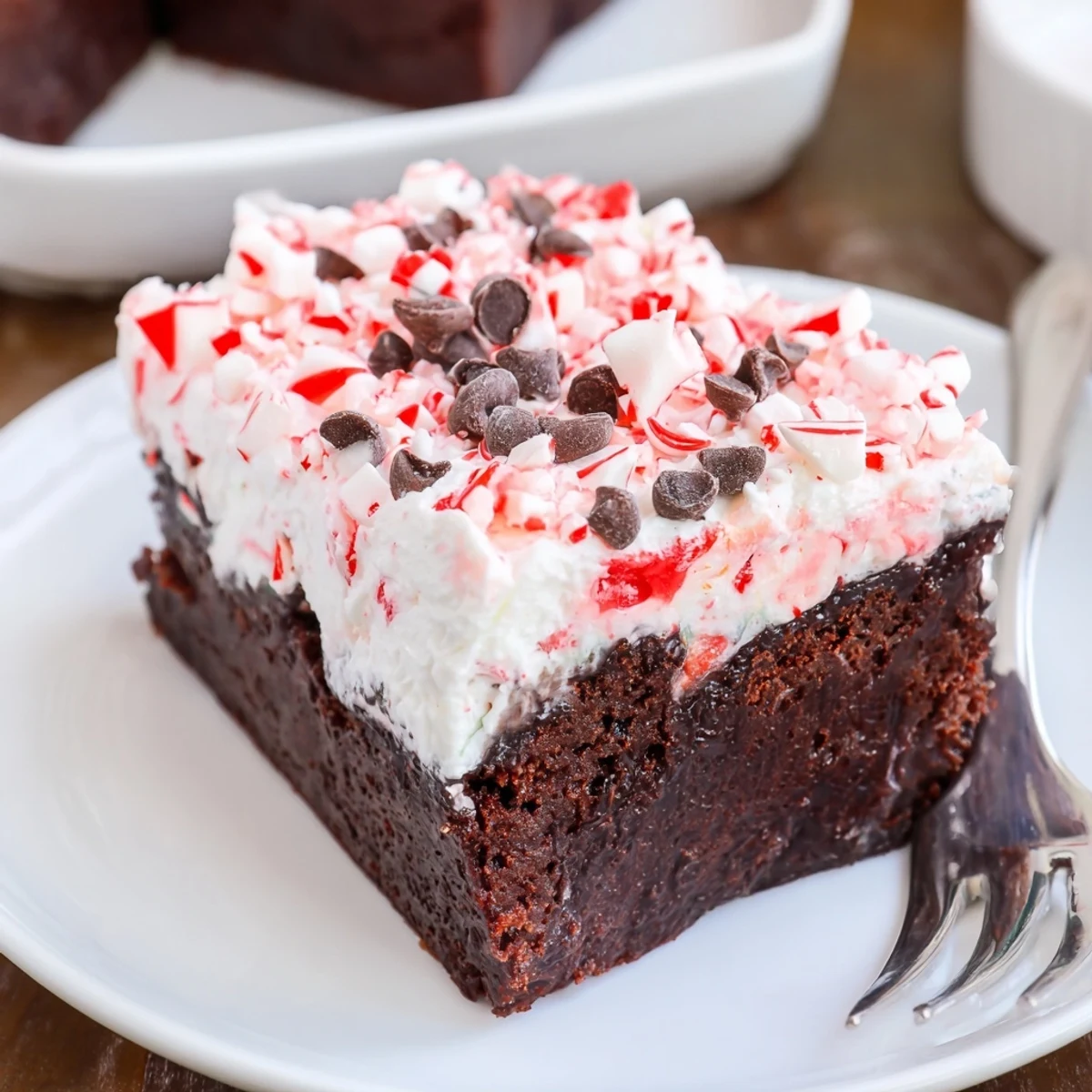 Slice of Peppermint Poke Cake revealing minty pudding pooled in holes