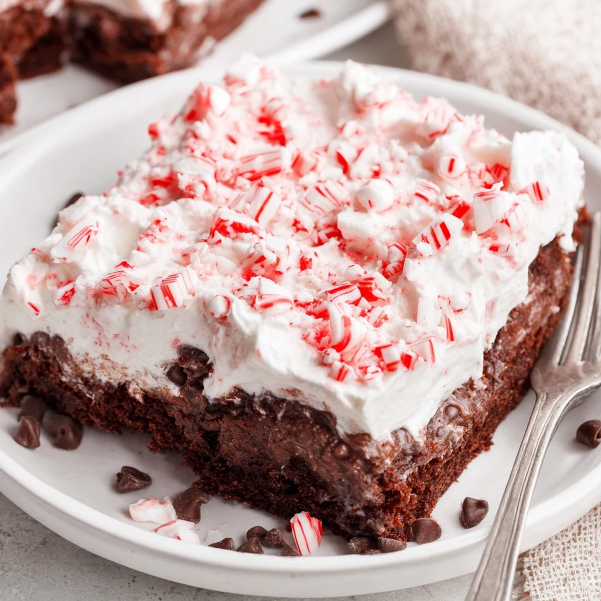 Peppermint Poke Cake with whipped topping, crushed candies, chilled and ready
