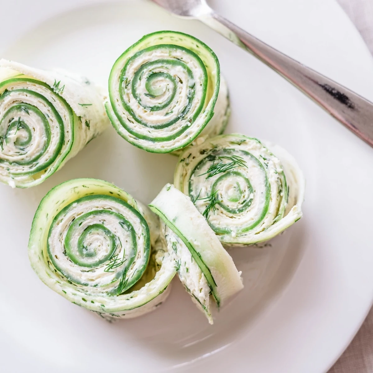 Cucumber And Dill Pinwheels on platter, creamy filling and crisp cucumber bites