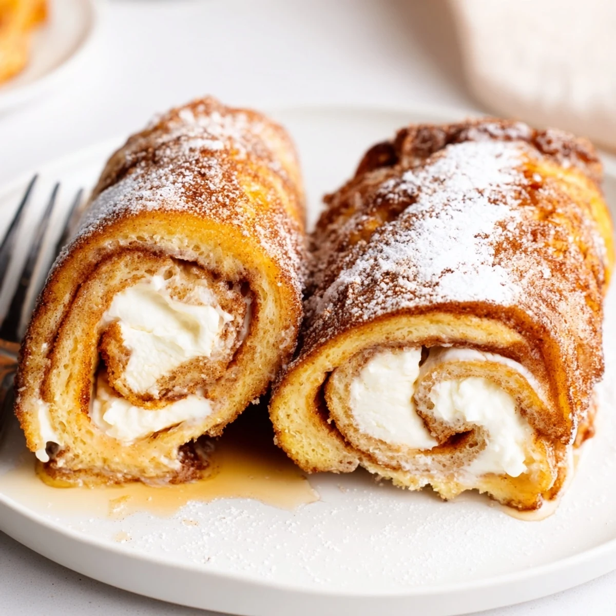 Skillet fried Cinnamon Roll French Toast Roll Ups with crisp edges, warm filling