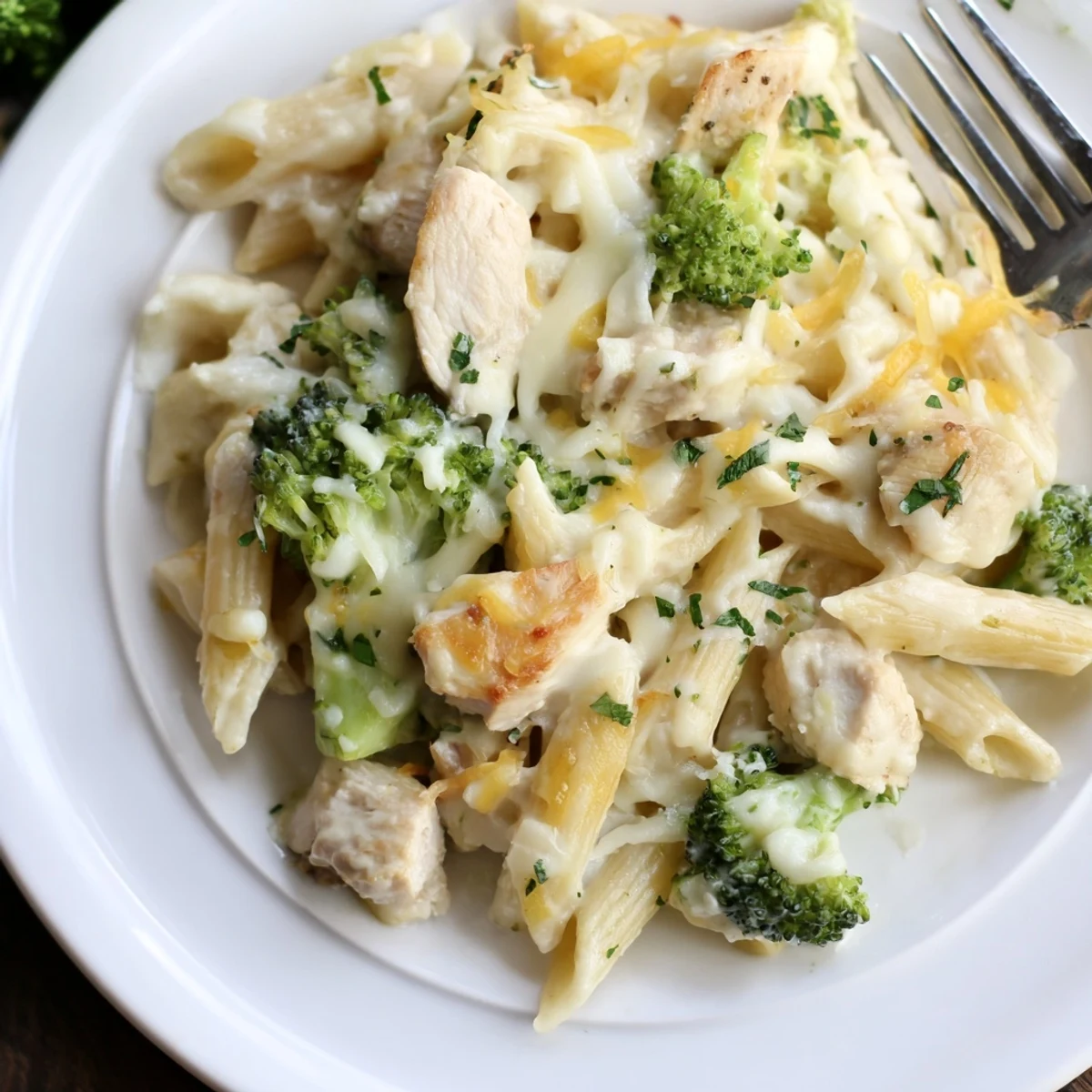 Creamy Chicken Broccoli Alfredo Bake bubbling golden, served with garlic bread.