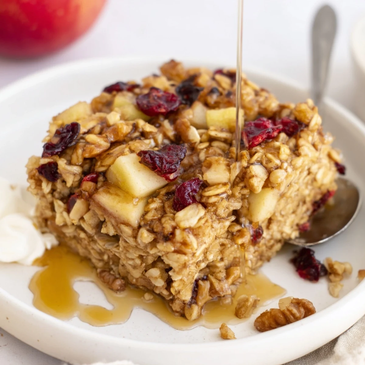 Hearty spoonfuls of Delicious Apple Cinnamon Oatmeal Bake Recipe For Mornings with maple drizzle