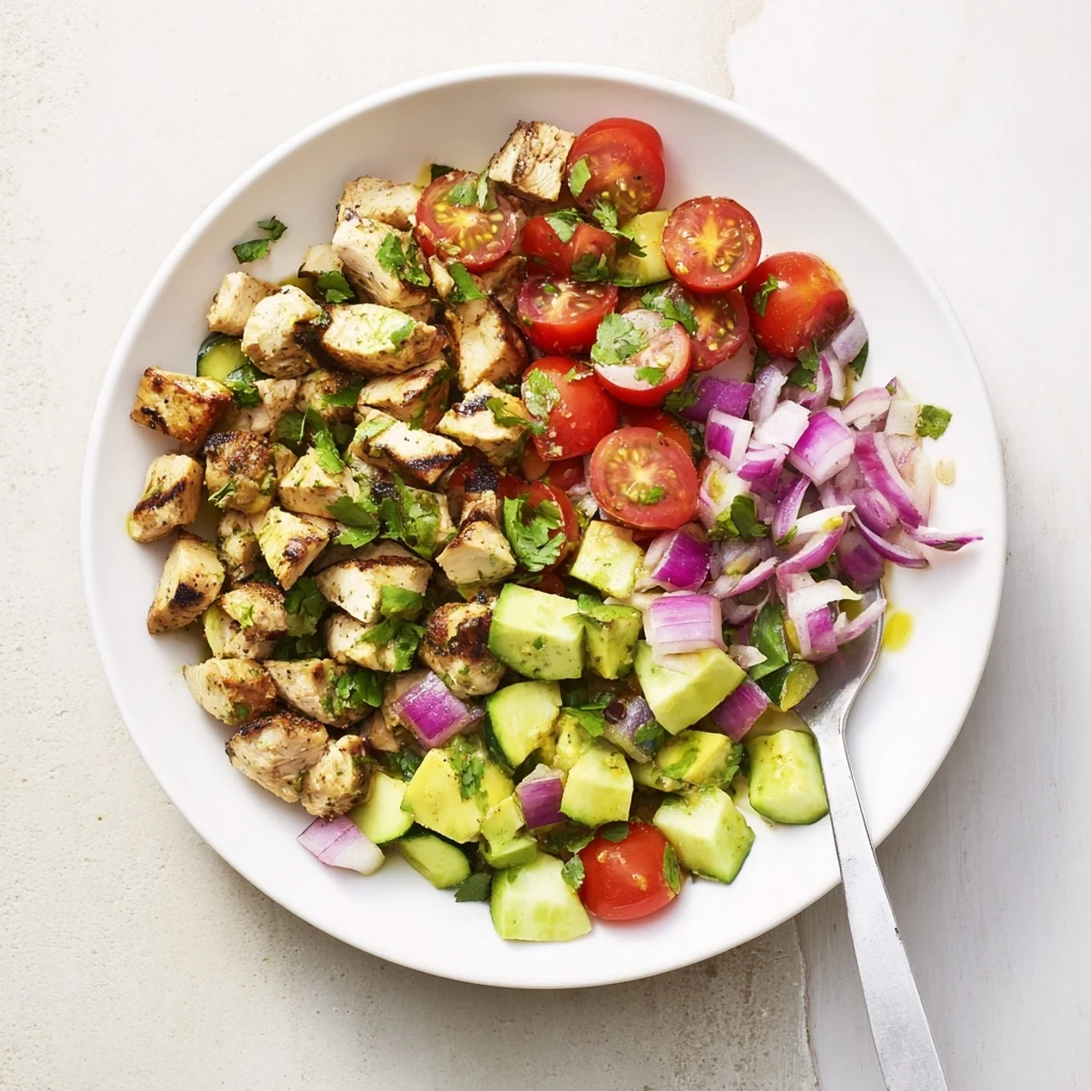 Colorful bowl of healthy avocado chicken salad with fresh vegetables and zesty lime dressing