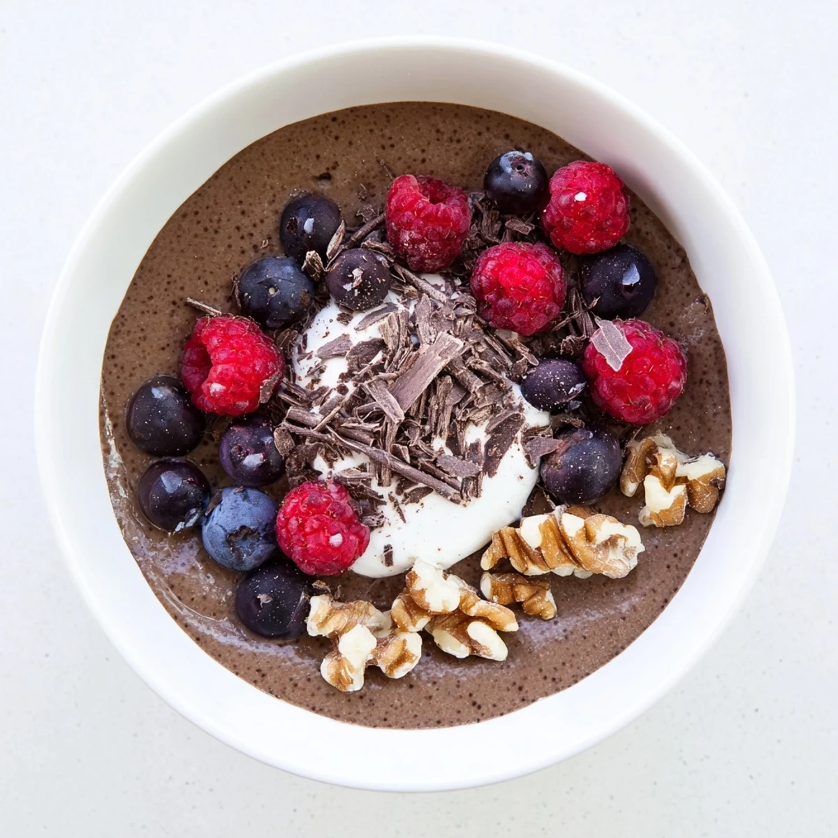 Healthy chocolate flaxseed pudding dessert with whipped cream and scattered berries on a wooden serving board