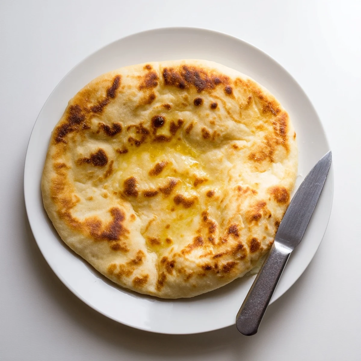 Soft Turkish Bazlama flatbread torn open revealing steamy interior perfect for dipping