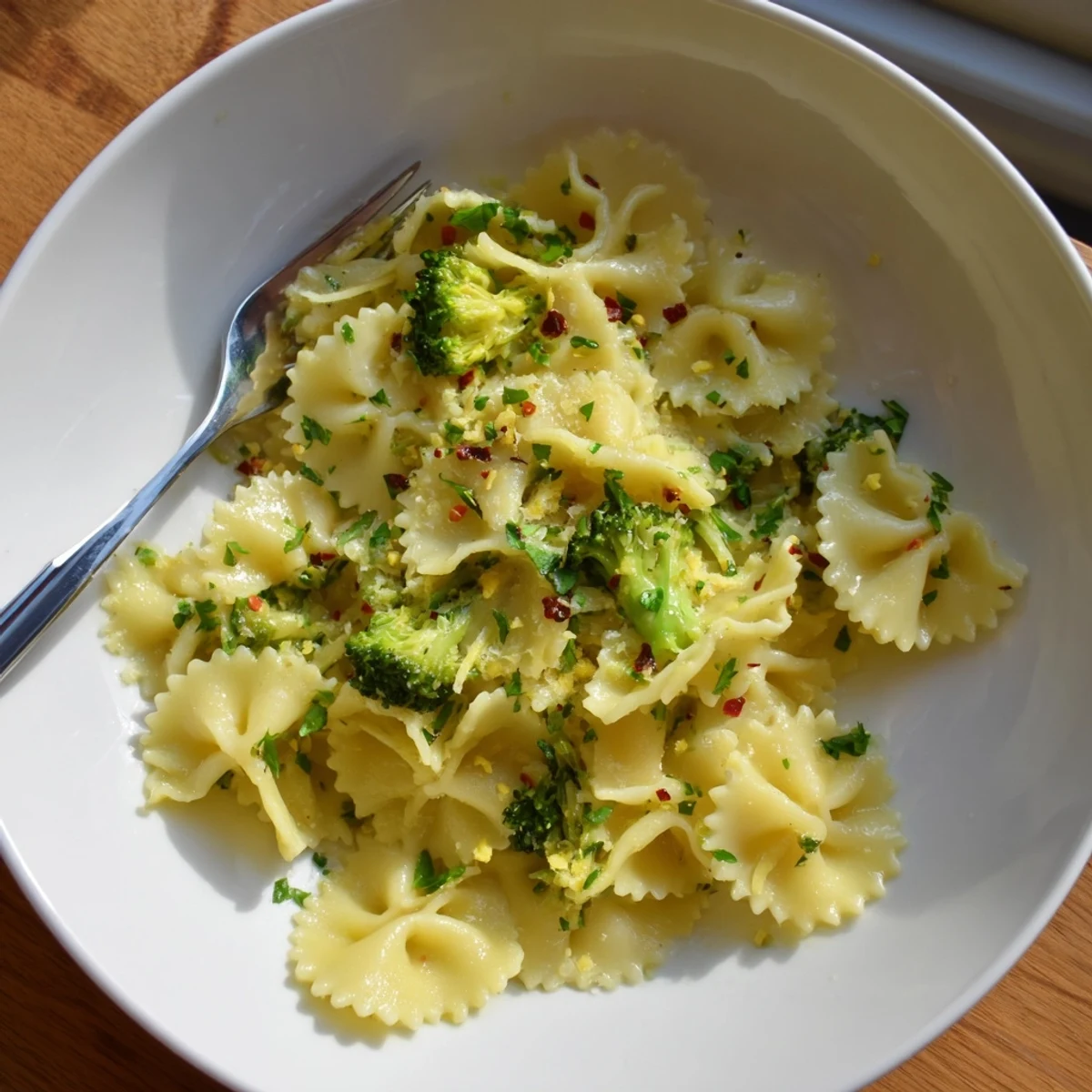 Golden mafaldine pasta with vibrant green broccoli florets coated in a silky lemon butter sauce
